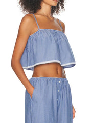 Woman wearing a blue and white striped top and pants on a white background