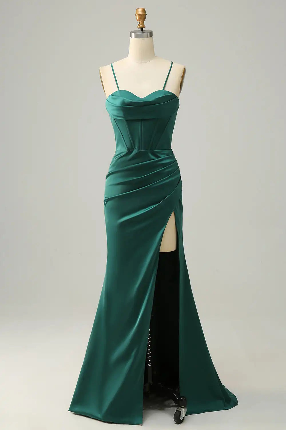 Green evening gown on a mannequin against a white background