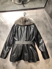 Black leather coat with fur collar on a hanger against a gray concrete wall.