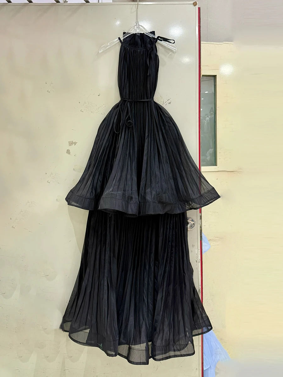Black evening gown on a hanger against a light background