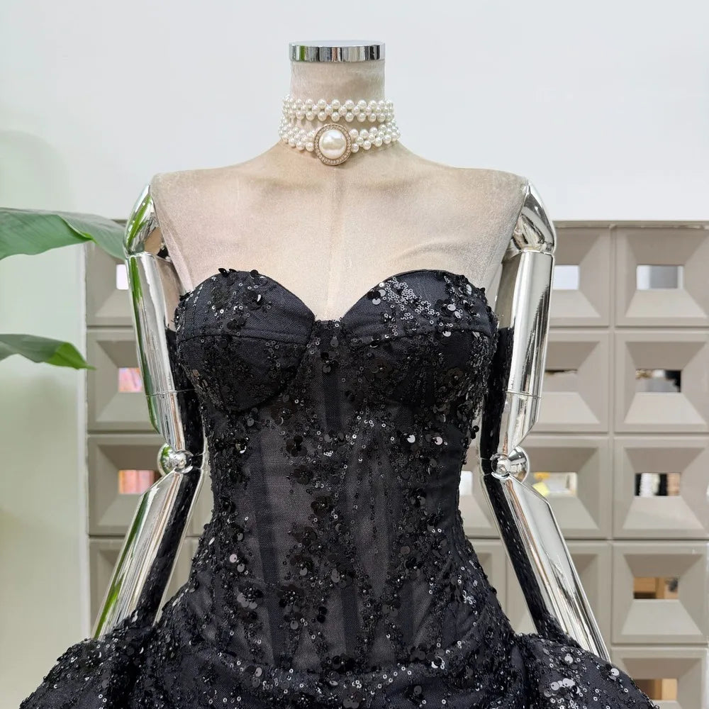 Close-up of black strapless floral lace mini dress bodice.