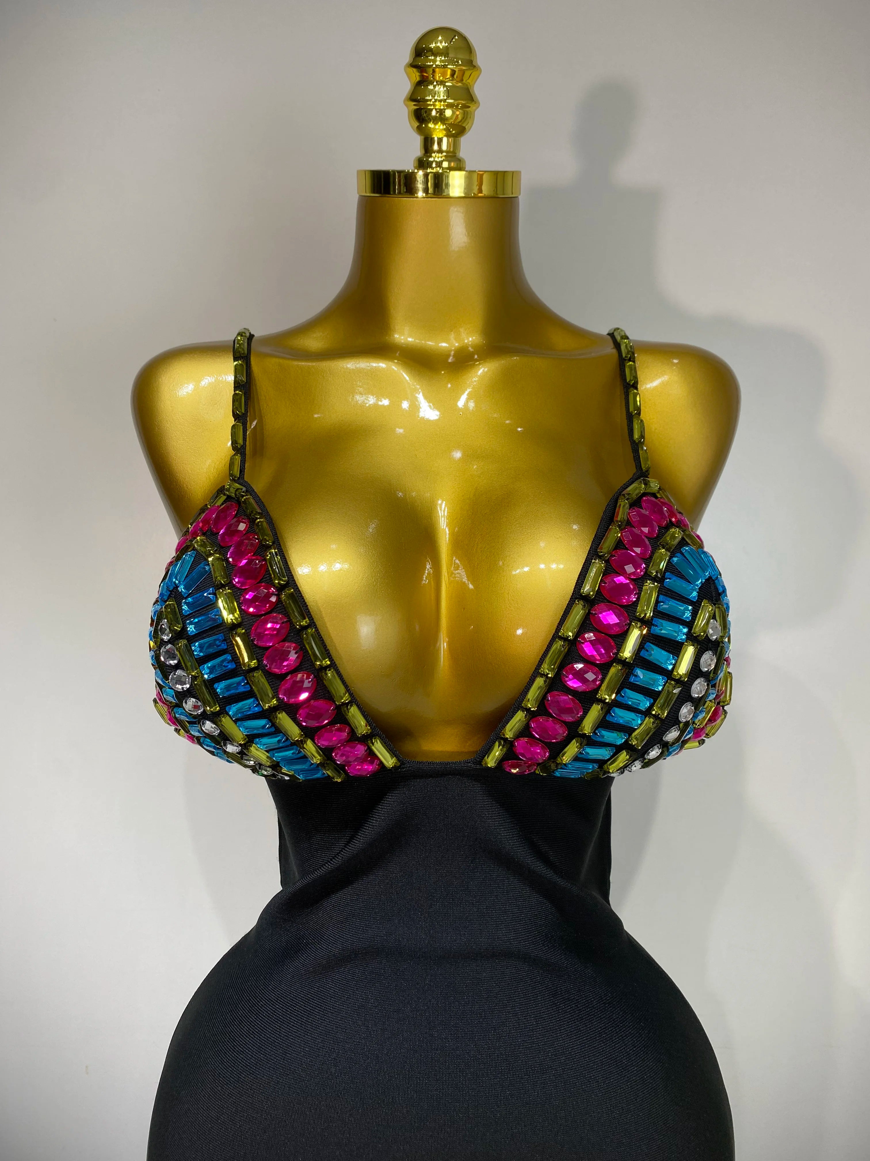 Mannequin wearing a colorful beaded top with a plain background