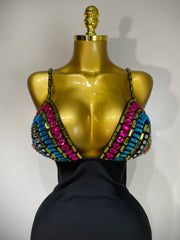 Mannequin wearing a colorful beaded top with a plain background