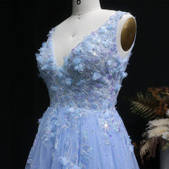 Blue evening gown with floral and beaded details on a mannequin against a dark background.