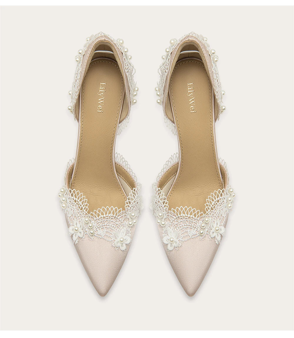 Pair of beige high-heeled shoes with lace detailing on a white background