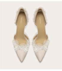 Pair of beige high-heeled shoes with lace detailing on a white background