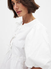 Woman wearing a white blouse with a plain background