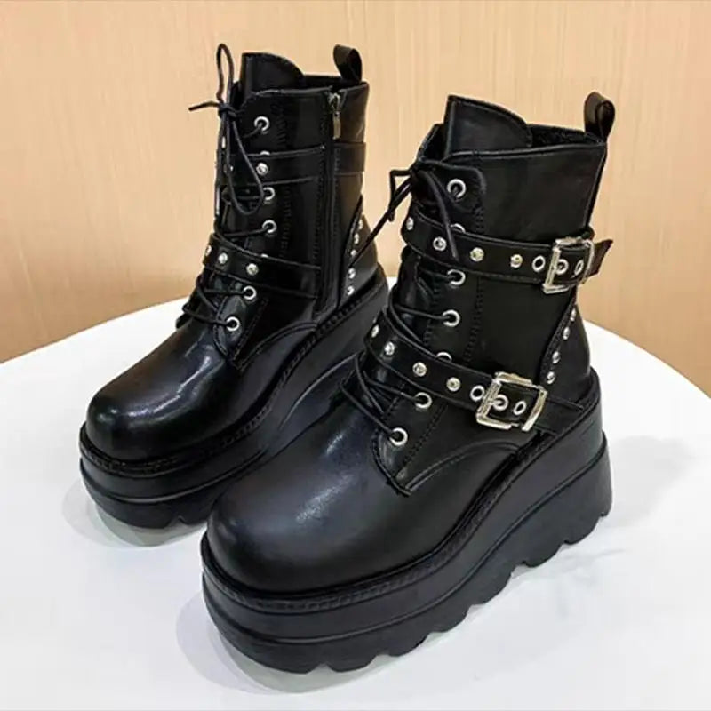 Black leather boots with buckles on a white surface