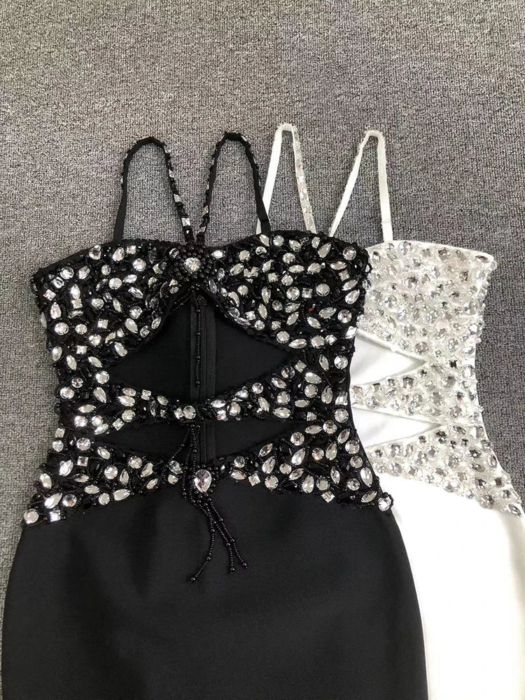Black strappy top with rhinestone embellishments on a gray background