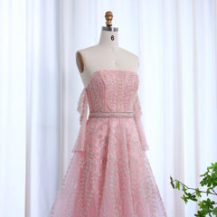 Pink evening gown on a mannequin against a white curtain background