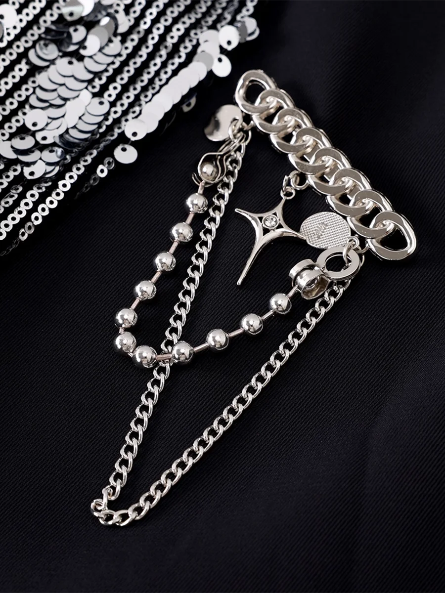 Silver chain and beaded accessory on a black background
