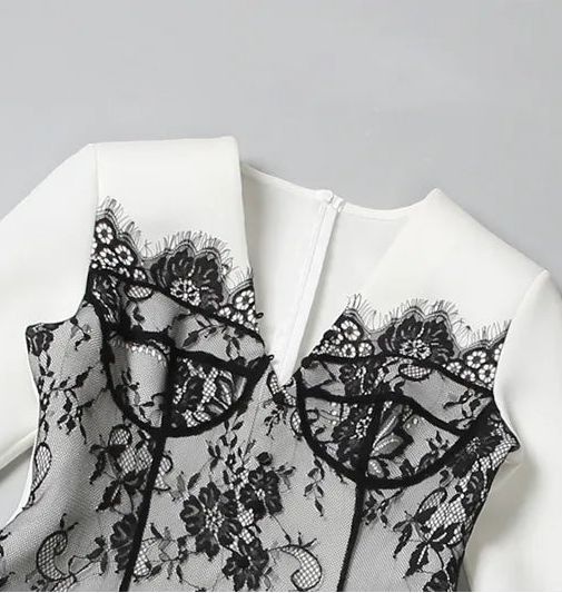 White blouse with black lace details on a gray background