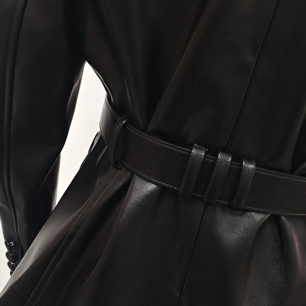 Close-up of a black leather coat with a belt on a light background