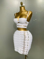 White and gold dress on a mannequin against a plain background