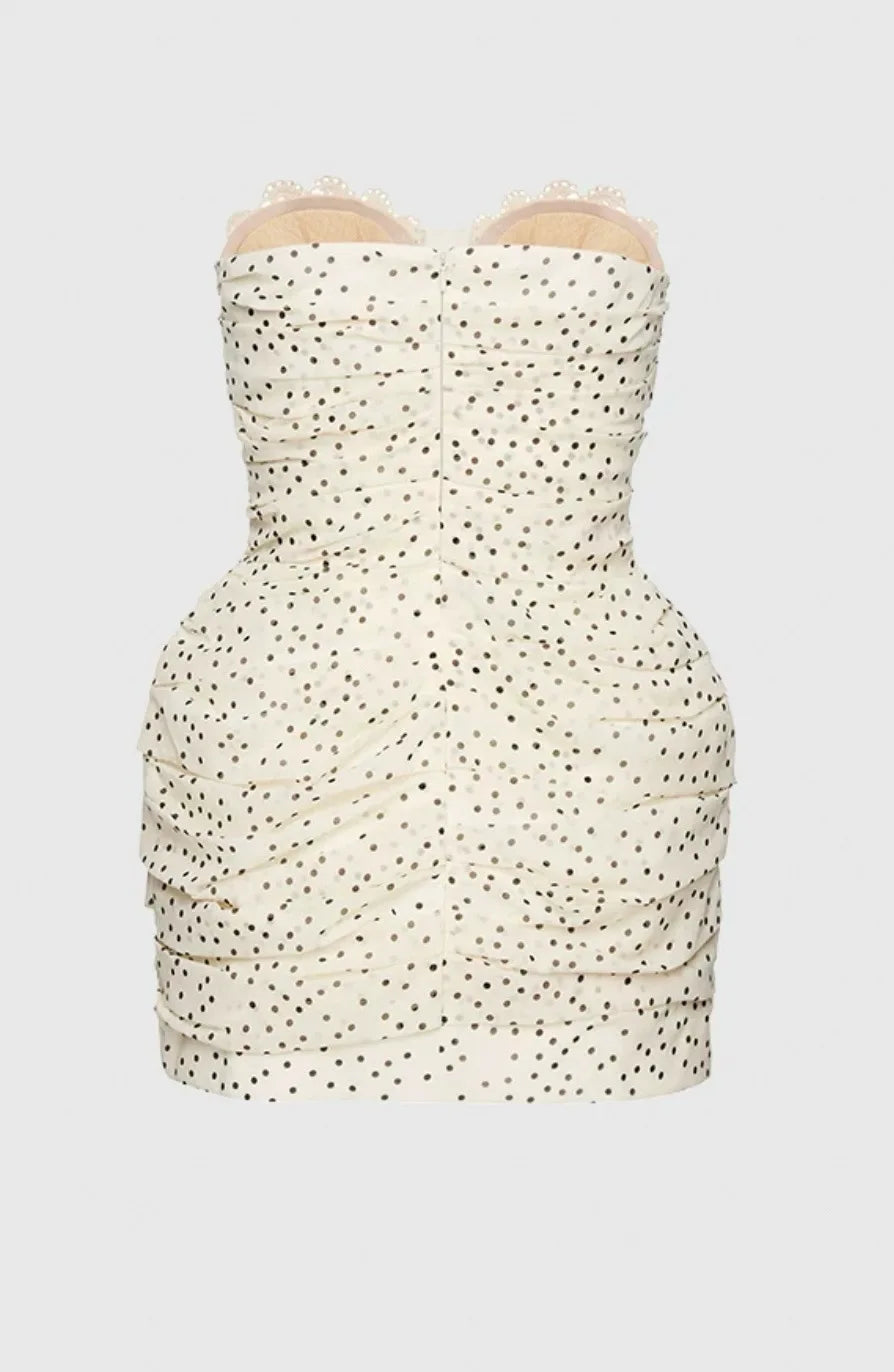 White strapless dress with black polka dot pattern on a white background