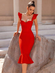 Woman in a red dress standing on stone steps with classical architecture in the background
