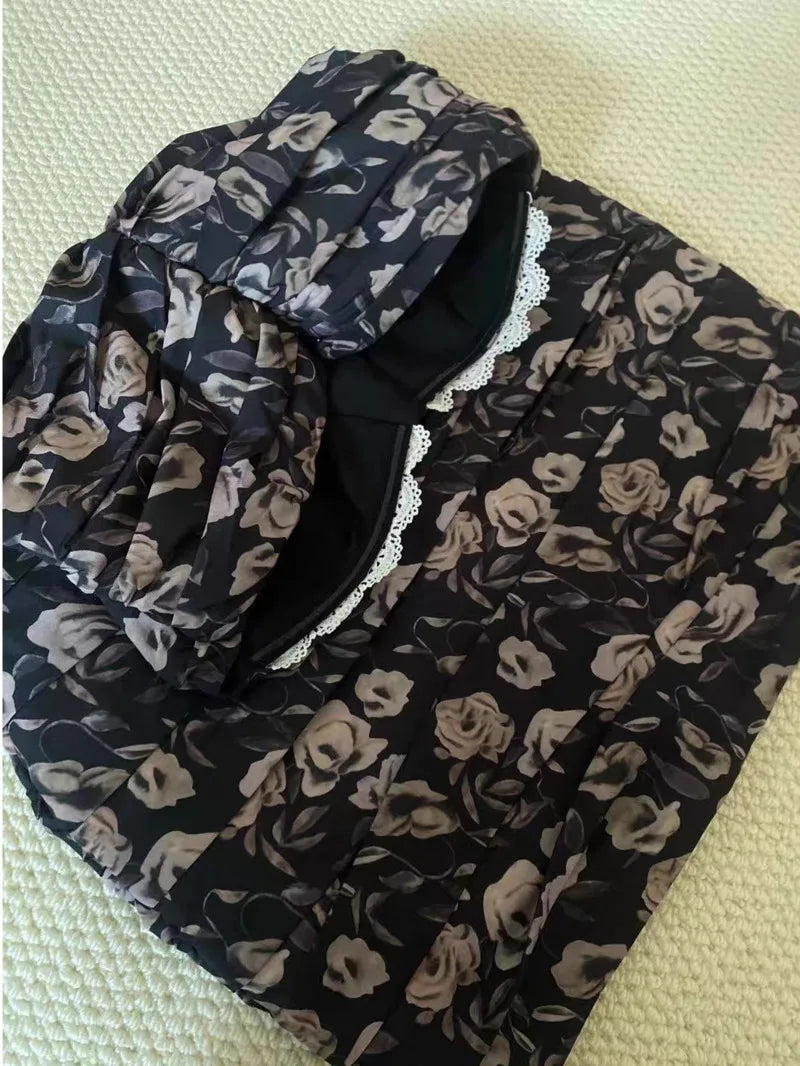 Floral patterned scarf with black background on a light green surface
