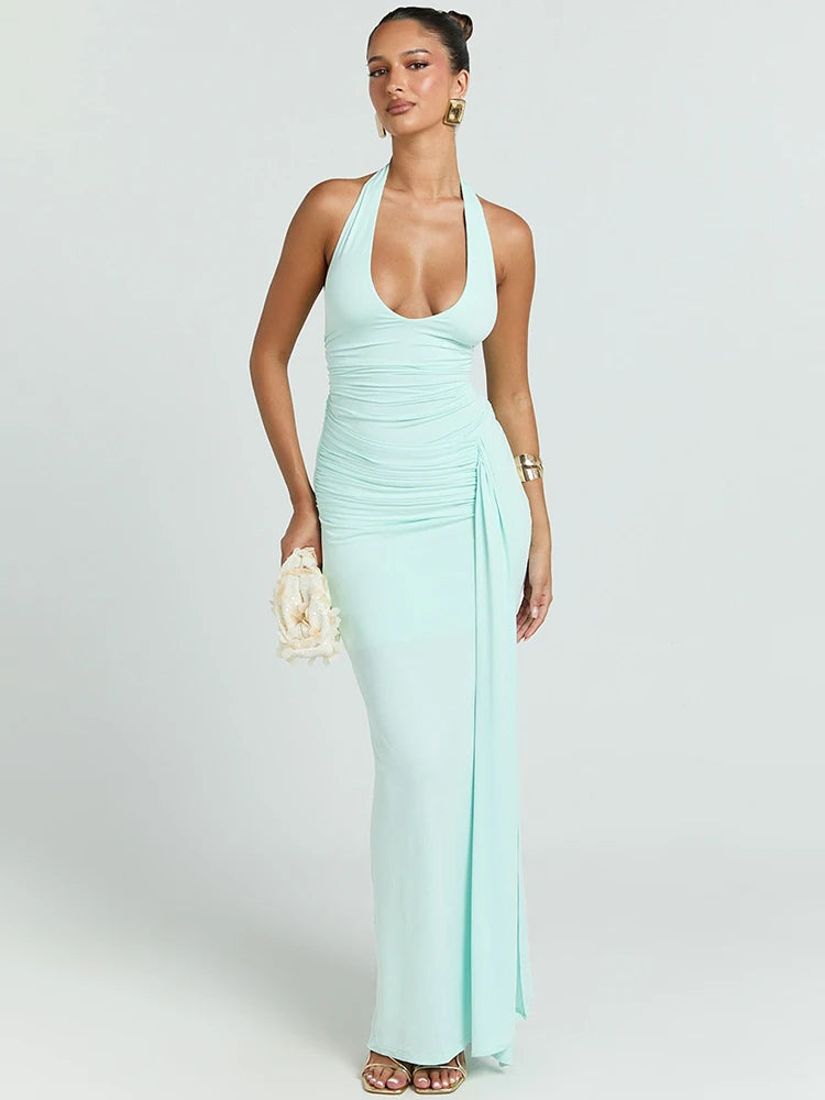 Woman wearing a mint green halter neck dress on a white background