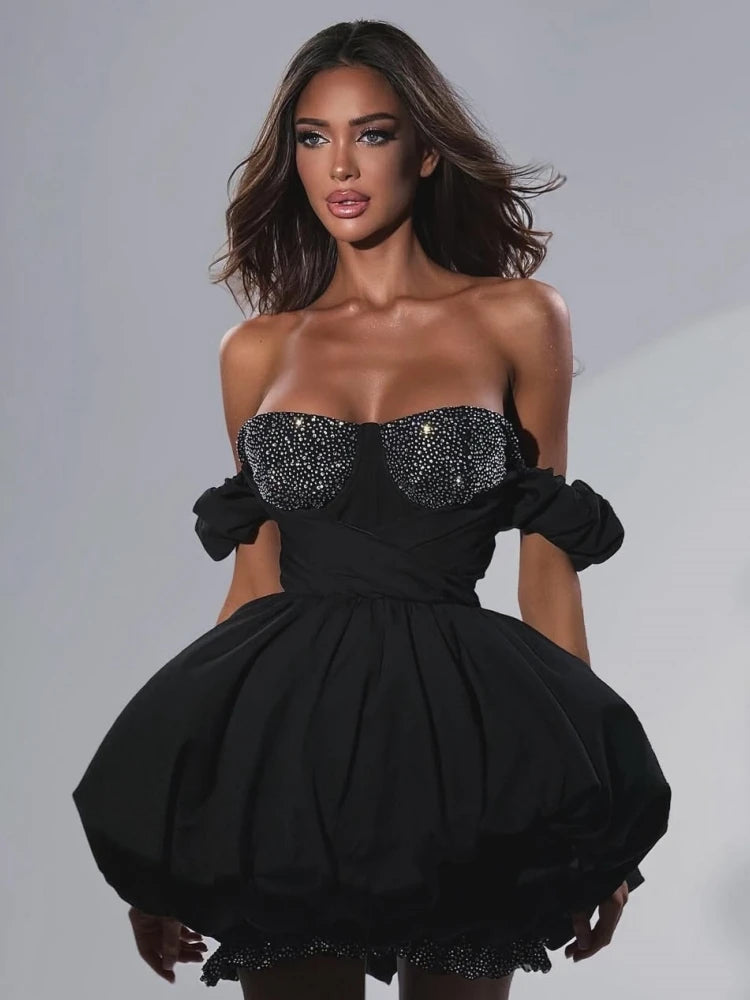 Black strapless dress with embellishments on a plain background