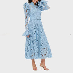 Woman wearing a light blue lace dress with ruffled sleeves on a white background