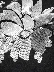 Close-up of a floral sequin pattern on a black background