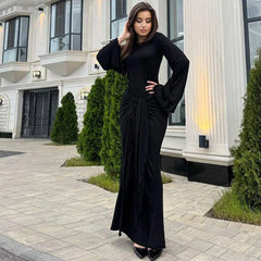Woman in a black dress standing in front of a building