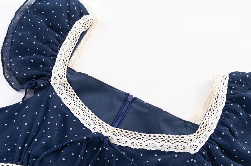 Close-up of the square neckline and lace trim on a blue polka dot midi dress.