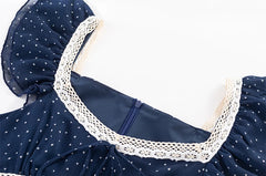 Close-up of the square neckline and lace trim on a blue polka dot midi dress.