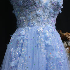 Close-up of a blue embroidered dress with floral details on a dark background