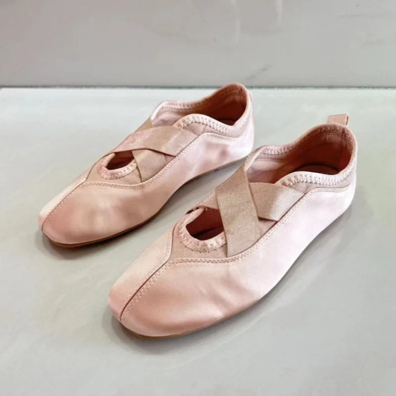 Pair of pink satin ballet flats with crisscross straps