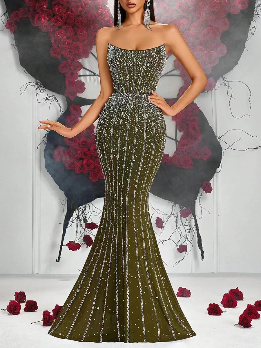 Woman wearing a sparkling green evening gown with a floral and black background