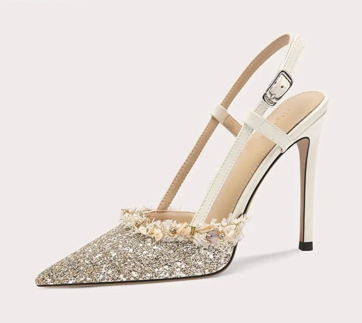 High-heeled shoe with glittery sole on a white background