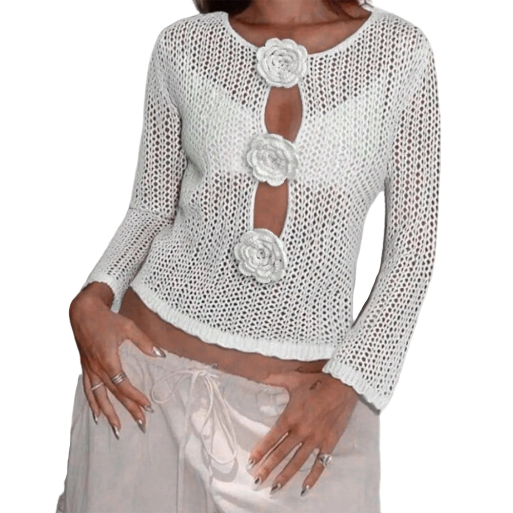 White knit top with floral embellishments on a white background
