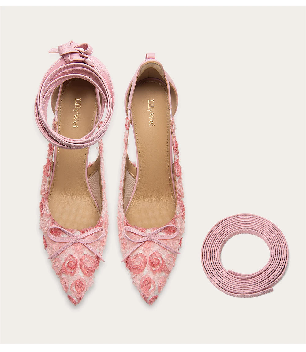 Pink lace-up shoes with floral design on a light background