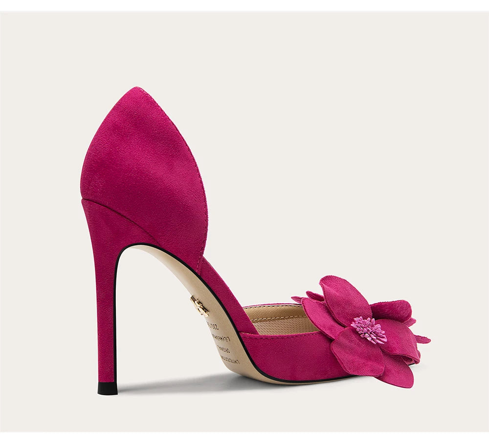 Pink high-heeled shoe with a flower detail on a light background