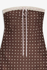 Brown strapless top with white polka dots and lace trim on a white background