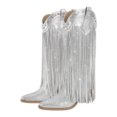 Silver cowboy boots with fringes and rhinestone embellishments on a white background