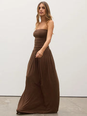 Woman wearing a brown strapless dress against a white background