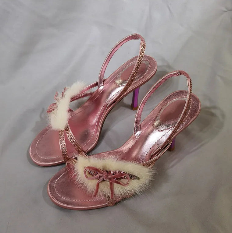 Side profile of a pink stiletto heel with faux fur and rhinestone details