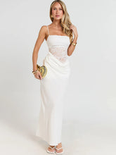 Woman wearing a white dress with gold accents on a plain background