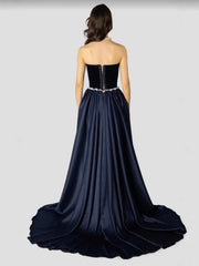 Navy blue evening gown with a strapless design and beaded waist on a white background