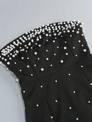 Black top with pearl embellishments on a light gray background