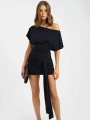 Woman wearing a black off-shoulder dress with a white background