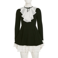 Black dress with white ruffled collar and hem on a mannequin against a white background