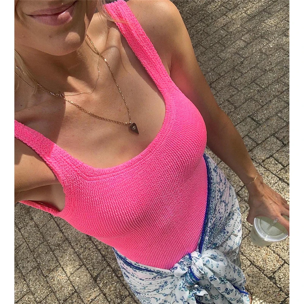 Pink ribbed high-cut one-piece swimwear worn by a woman