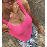 Pink ribbed high-cut one-piece swimwear worn by a woman