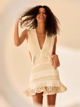 Woman wearing a white crochet dress against a neutral background