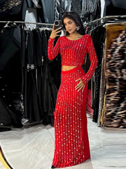 Woman in a red dress taking a mirror selfie in a clothing store.