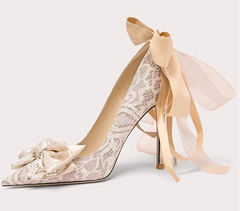 High-heeled shoe with lace design and ribbon on a white background