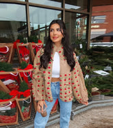 Person wearing a beige floral print plush fleece jacket with blue jeans.